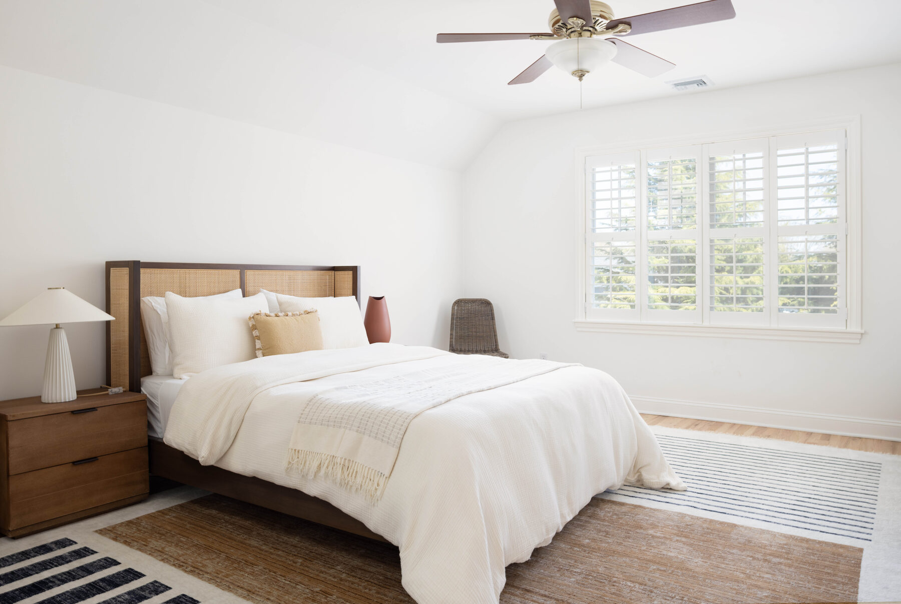 Junior suite — cane headboard with a terracotta vase in the corner
