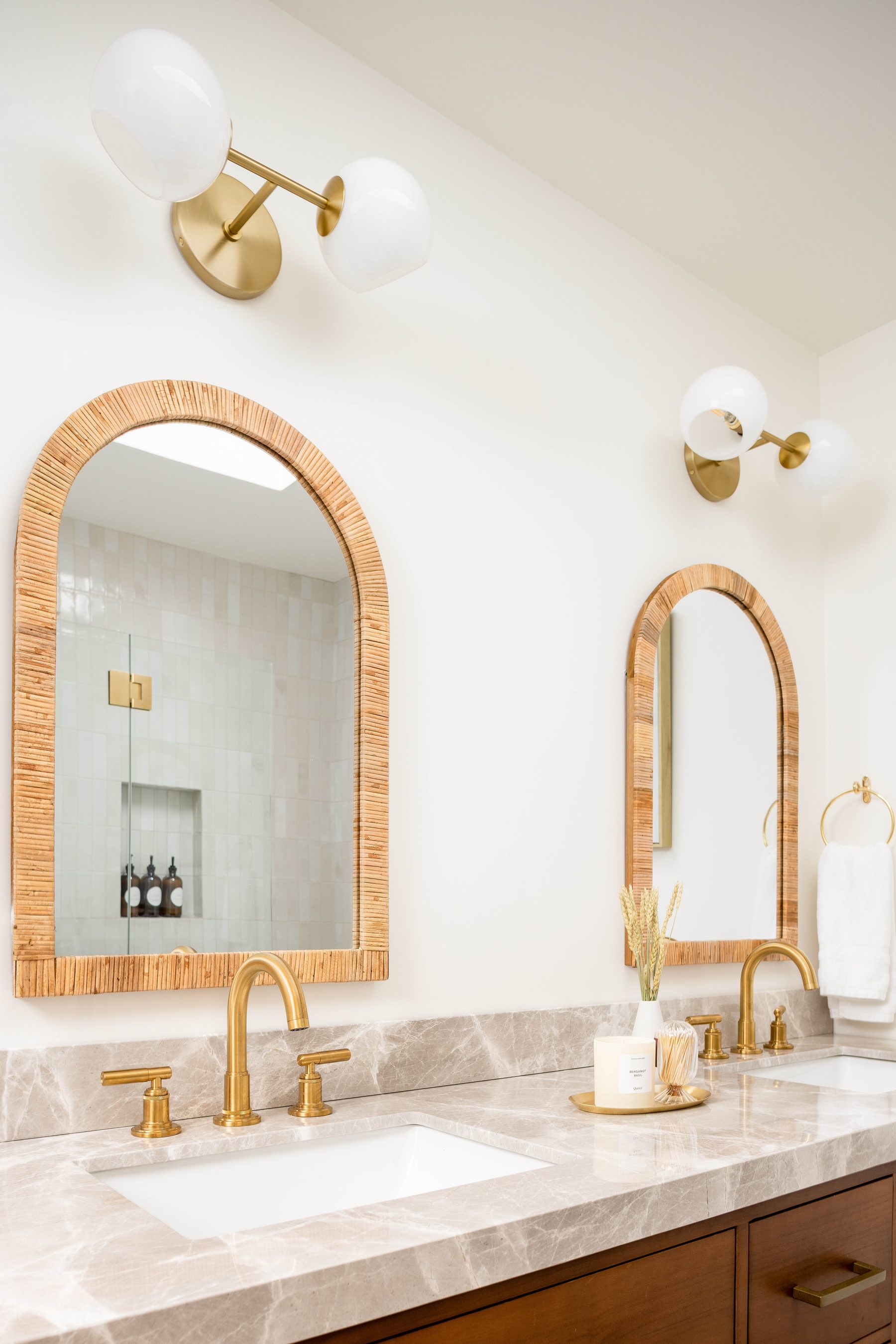 Guest bath — brushed-gold fixtures with twin arched mirrors