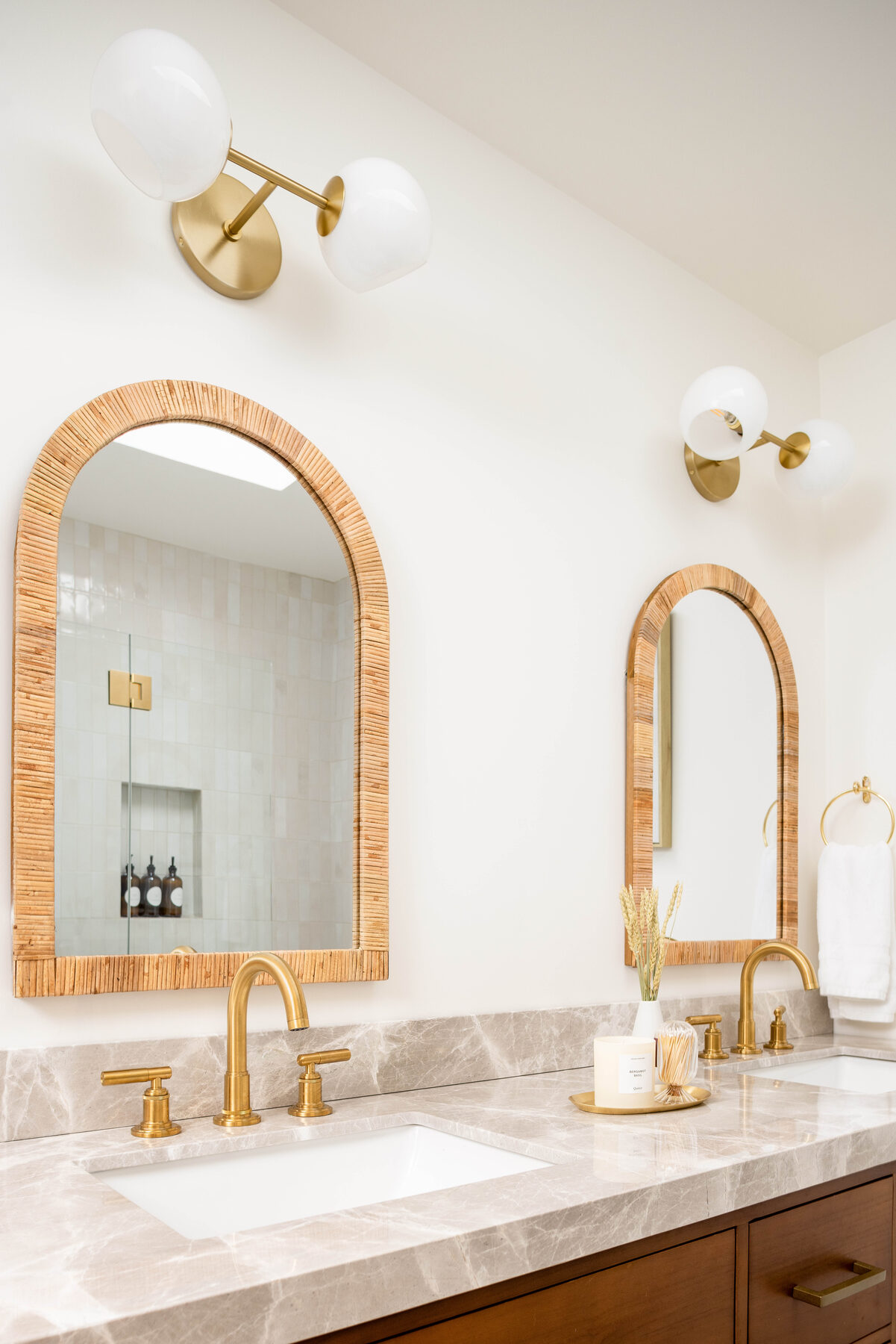 Guest bath — brushed-gold fixtures with twin arched mirrors