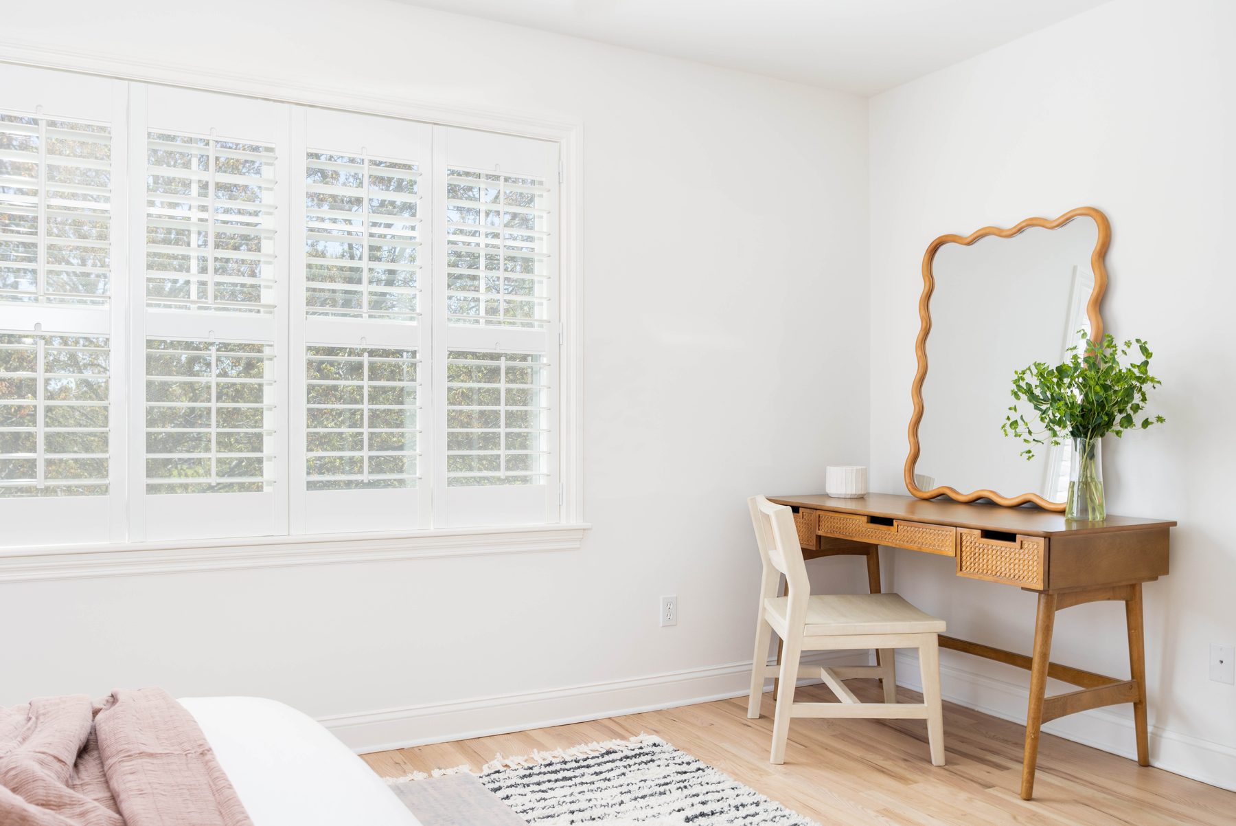 Guest room — scalloped vintage mirror over a writing desk