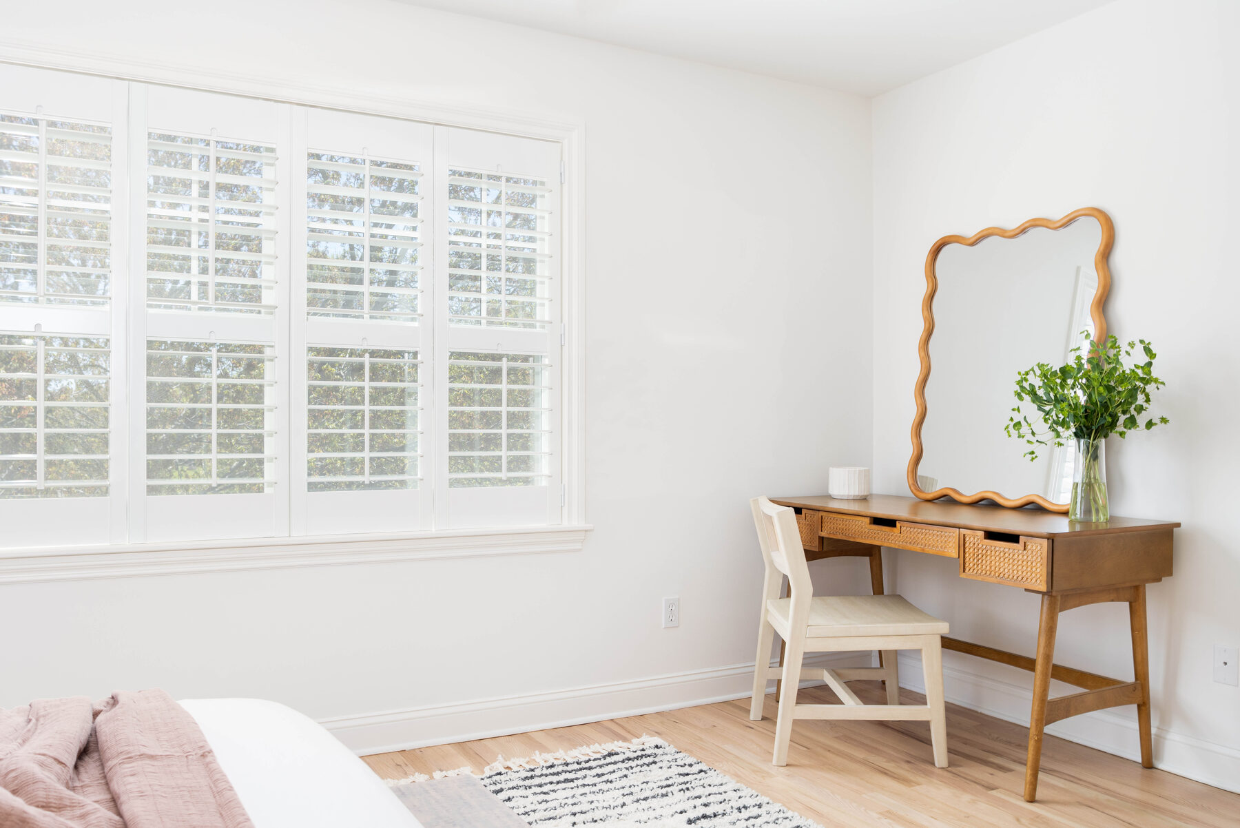 Guest room — scalloped vintage mirror over a writing desk