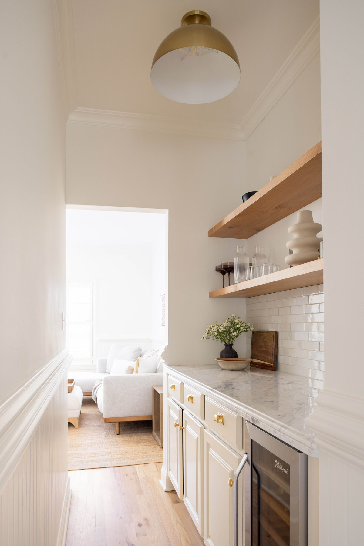 Wet bar with floating shelves and beverage fridge